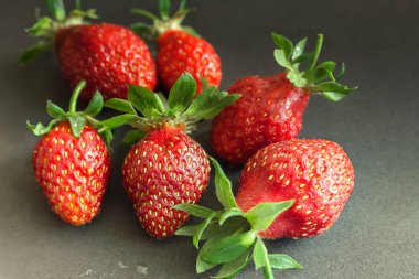 Siyah arka planda olgun kırmızı çilekler..