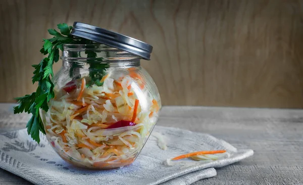 Sauerkraut with carrots in a glass jar. — Stock Photo, Image