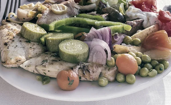Meat, fish and various vegetable garnish on a plate. — Stock Photo, Image
