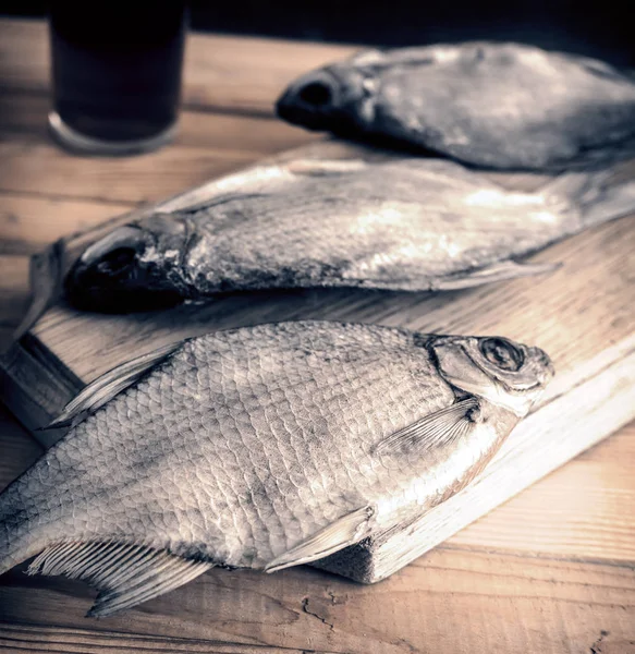 Сушена риба на столі і келих пива — стокове фото