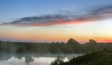 Güneşin gölün üzerinde doğduğu sabah manzarası