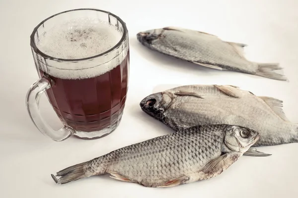 Pesce secco sul tavolo e un bicchiere di birra — Foto Stock