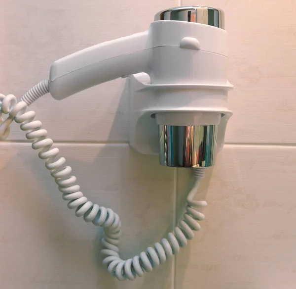 Secador de cabelo pequeno na parede do banheiro — Fotografia de Stock