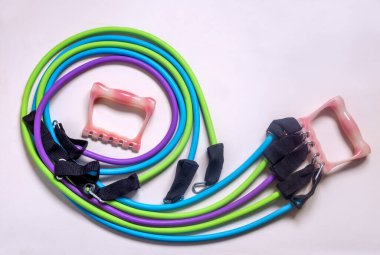 Çeşitli grupların kaslarını güçlendirmek için elastik bant ve tutacakları olan spor genişleticisi, çok işlevli. Koronavirüs enfeksiyonu salgını nedeniyle kısıtlamalar sırasında evde eğitim için kullanılabilir..