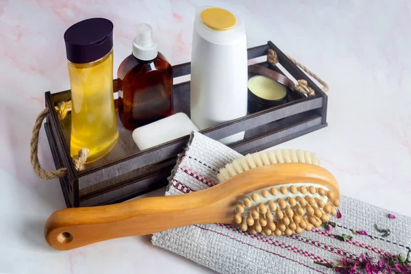 Doğal ahşap, doğal kıllar ve vücut bakım ürünlerinden yapılmış selülit önleyici masaj fırçası. Sağlıklı yaşam tarzı kavramı. Lenfatik drenaj masajı.