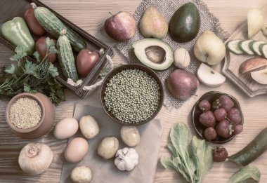 Tahta masadaki çeşitli organik gıda ürünleri: meyve, sebze, yumurta, bulgur gevreği, lahanalı fasulye. Sağlıklı beslenme kavramı. Yukarıdan görünüşü