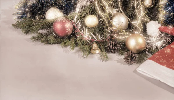 カラフルなクリスマスの装飾 松のコーンと松の枝 青い背景にサンタクロースの帽子 コピースペース付きフロントビュー — ストック写真