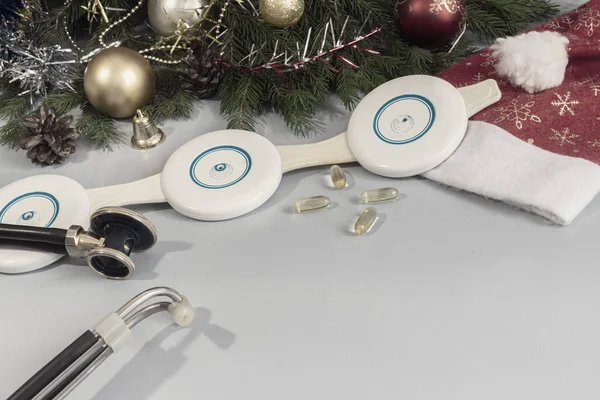 理学療法装置 聴診器 クリスマスの装飾付きの医療ポスター ガーランド おもちゃ サンタの帽子 コピースペース 薬のクリスマス — ストック写真