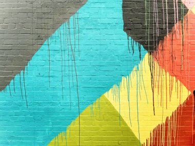 Tuğla duvar gri, mavi, siyah, sarı, turuncu, kırmızı ve limon yeşili renklerle kaplandı