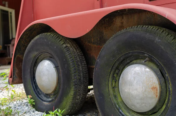 Çiftliğin yanındaki ahırda eski model tekerlek kapaklı eski kırmızı römork.