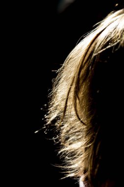 Siyah bir arka planda sarı saçlar.