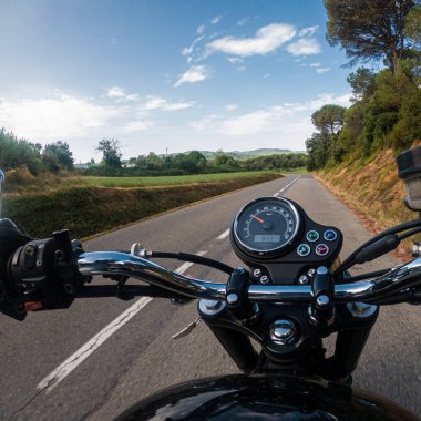 Dönüş yolunda hız göstergesi olan eski siyah bir motosiklete binmek.