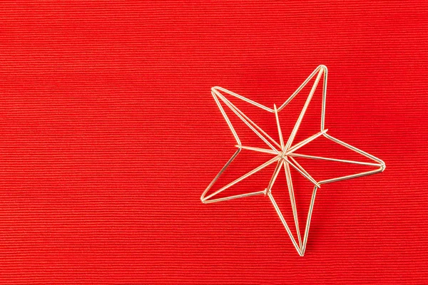 gold frame star christmas decoration on red textile background, copy space