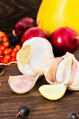 sarımsak ve yetiştirilen kabak, kırmızı soğan, rowan, kuşburnu ve ahşap arka plan üzerinde sonbahar yaprakları ile sonbahar kavramı