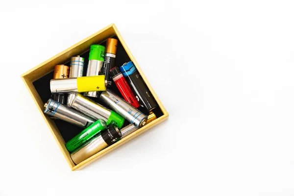 Las pilas AA usadas en una caja están listas para la correcta eliminación y reciclaje de sustancias tóxicas para el medio ambiente y el suelo sobre un fondo claro. Tratamiento de sustancias peligrosas y reciclables . — Foto de Stock