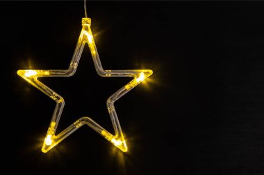 Koyu tebeşir tahtası nın arka planında yıldız şeklinde Noel ışıkları. Sarı aydınlatma, Noel dekor, kopya alanı.
