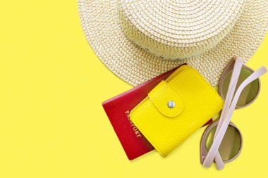 Şapka, güneş gözlüğü ve deri çantalı pasaport. Yaz tatili geçmişi. Yaz zamanı, seyahat, sahil, dinlenme, turizm konsepti. Kopyalama alanı olan sarı arkaplan.