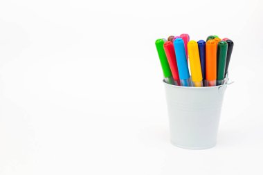 Açık arkaplanlı beyaz metal bir kovaya çok renkli işaretler koyun, boşluğu kopyalayın. Keçeli kalem, kalem, sanatçı aletleri, yaratıcılık, boş zaman, hobi. Renkli okul malzemeleri.