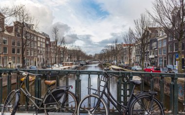 Hollanda 'da Amsterdam bölgesinin ve sahildeki kanallar. Amsterdam 'da kış sezonunda bulutlu bir gün, Hollanda. Bu modern şehir, her yıl binlerce turist çekiyor.