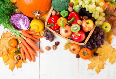 Taze ve olgun sonbahar sebze ve meyve rustik ahşap bir masa üzerinde ürün yelpazesine. Üstten görünüm