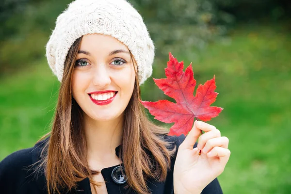 Hermosa Joven Con Gorra Lana Sosteniendo Una Hoja Roja Otoño — Foto de Stock