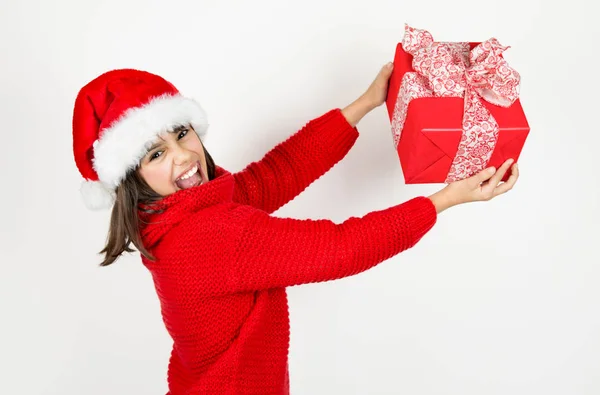 滑稽和可爱的小女孩与圣诞老人帽子和红色毛衣拿着红色圣诞礼物 在白色上隔离 — 图库照片