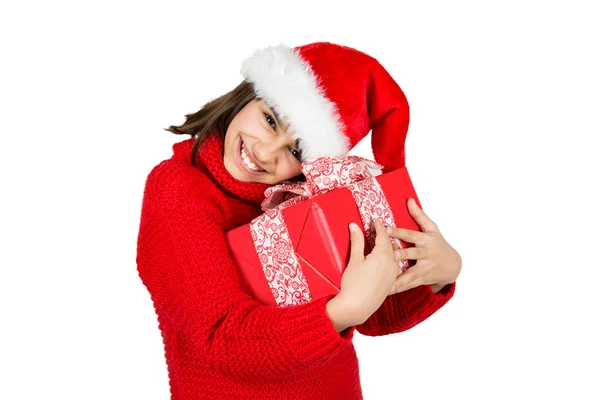 快乐和可爱的小女孩与圣诞老人帽子和红色毛衣拥抱一个红色的圣诞礼物 在白色上隔离 — 图库照片
