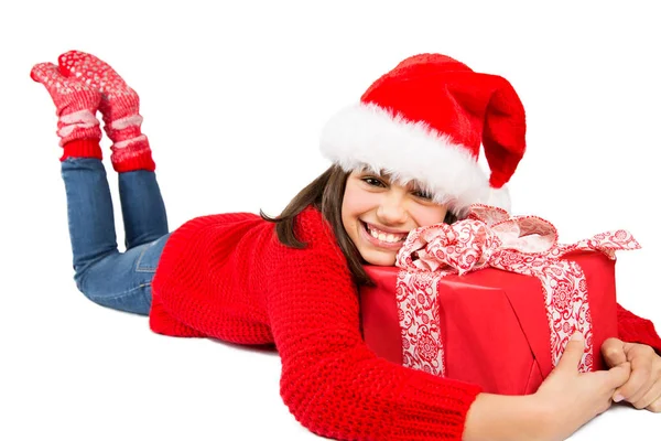 サンタの帽子と赤いセーター赤クリスマスを抱いて幸せとかわいい女の子を床に横になって提示します 白で隔離 — ストック写真