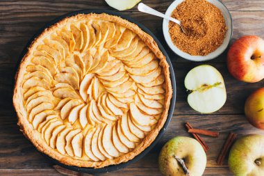 Rustik ahşap bir masa üzerinde doldurma muhallebi ile taze pişmiş elmalı turta tart. Üstten görünüm