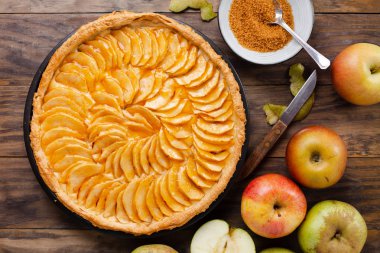 Krema dolum ve reçel kapağında rustik ahşap bir masa ile geleneksel elmalı turta tart. Üstten görünüm