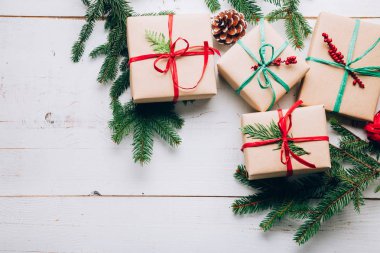 Yay ile kağıt zanaat, rafya Noel hediyeleri, çam dalları koniler ve kırmızı meyveler bir beyaz tahta masada pin. Yat, alanı Kopyala