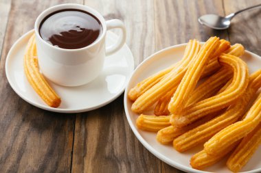 Geleneksel İspanyol churro rustik ahşap bir masa üzerinde sıcak çikolata sos ile