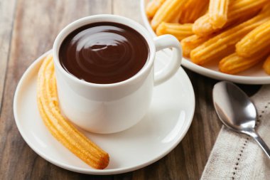 Geleneksel İspanyol churro rustik ahşap bir masa üzerinde sıcak çikolata sos ile