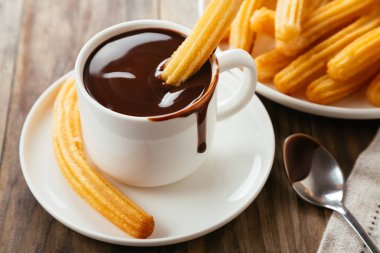 Geleneksel İspanyol churro rustik ahşap bir masa üzerinde sıcak çikolata sos ile