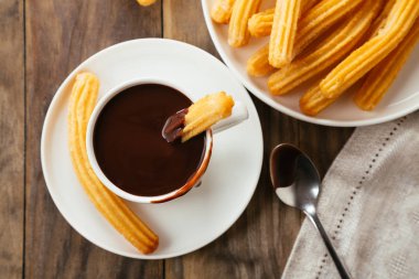 Geleneksel İspanyol churro rustik ahşap bir masa üzerinde sıcak çikolata soslu. Üstten görünüm