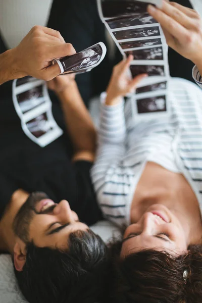Happy Excited Pregnant Couple Looking Ultrasound Images Baby Lying Bed — Stock Photo, Image