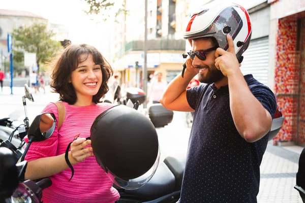 Pareja joven que se pone el casco para montar una motocicleta — Foto de Stock