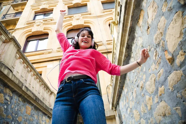 Happy girl with headphones dancing in the street — Stock Photo, Image