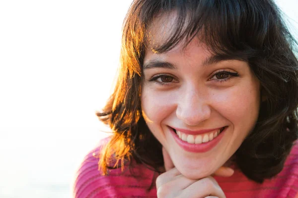 Portrait of a smiling young woman at sunset — Stock Photo, Image