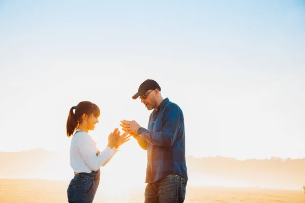 Otec a dcera hraje hru rukou na pláži při západu slunce — Stock fotografie