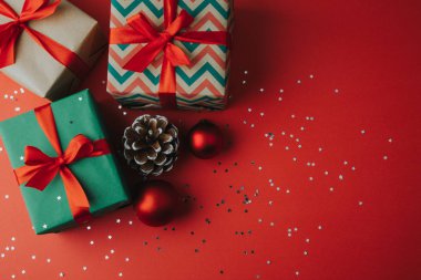 Kırmızı bir arka plan üzerinde Noel hediyeleri ve süsler