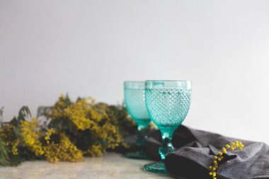 Mavi Vintage kadehler ve sarı Mimoza çiçekler. Kadehlerin değildir arka plan üzerinde.