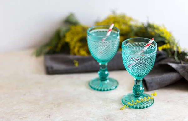 Refhesing drink in blue vintage goblets on the white background with srping flowers. — Stock Photo, Image