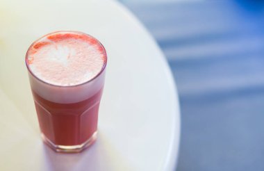 Beyaz arka plan üzerinde masada köpük ve kahve sanatı ile Tatlı pembe stawberry kahve latte. Menü için kopya alanı.