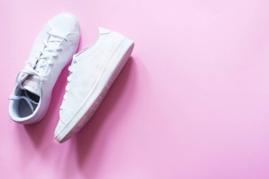 Pembe arka planda şık, modaya uygun, hipster çift beyaz spor ayakkabı