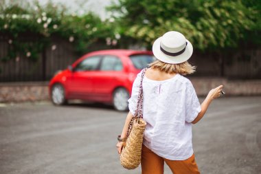 Kadının elinde kırmızı otomobilin anahtarı var. Otomatik konsept kirala veya satın al.