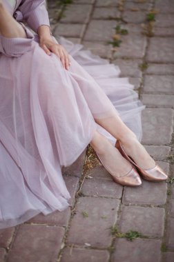 Zarif bayan parlak pembe altın ayakkabı ve trendy havadar fatin dantel etek giymek. Şık düğün moda pompaları kadın bacaklar.