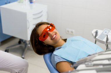 Genç bir kadın dişçiye gidiyor ve gülümsüyor..