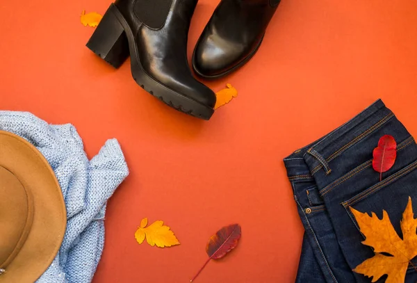 Жіночий одяг - синій тумблер і джинси на фоні теракоти, вид зверху. Зима, осінь жіночий одяг Ліцензійні Стокові Фото