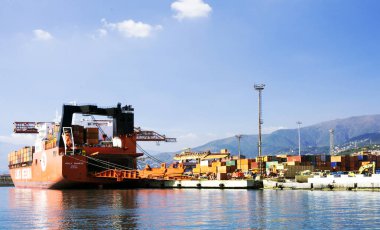 Cenova, İtalya, Ekim 2018. Kapsayıcılar bir turuncu renkli kargo gemisi Port Cenova İtalyan şehir üzerine yükleniyor.